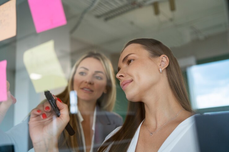 Foto grátis mulheres que trabalham com post-its de baixo ângulo