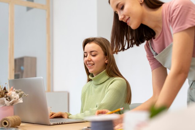 Mulheres que trabalham lateralmente de sua mesa