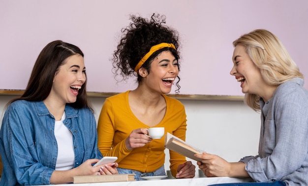 Mulheres rindo felizes tomando café