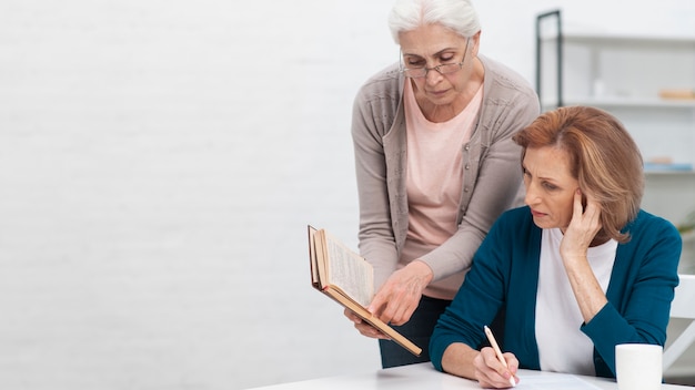 Foto grátis mulheres sênior, olhando para um livro