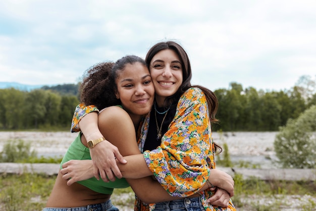 Mulheres sorridente de tiro médio se abraçando