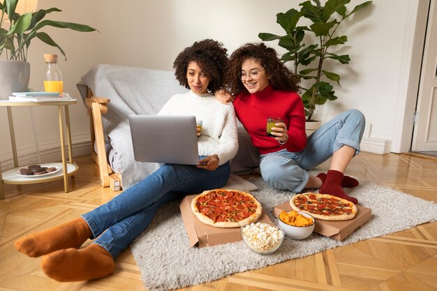 Mulheres sorridentes de tiro completo assistindo filmes