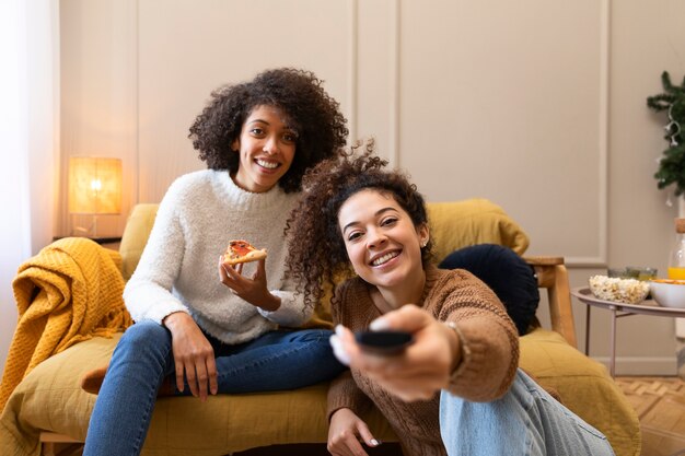 Mulheres sorridentes de tiro médio com controle remoto