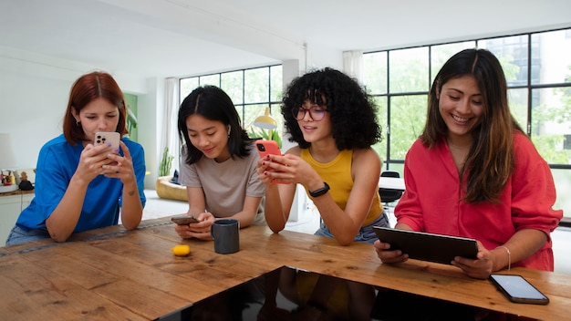 Mulheres sorridentes de tiro médio com dispositivos