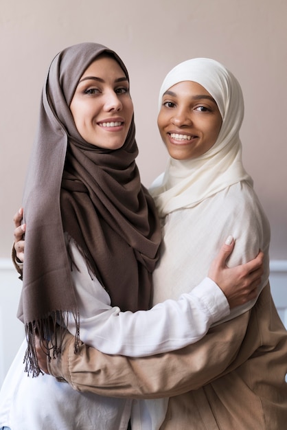 Mulheres sorridentes de tiro médio com hijab