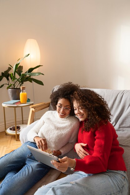 Mulheres sorridentes de tiro médio com tablet