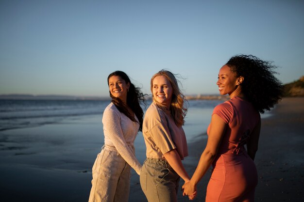 Mulheres sorridentes de tiro médio de mãos dadas