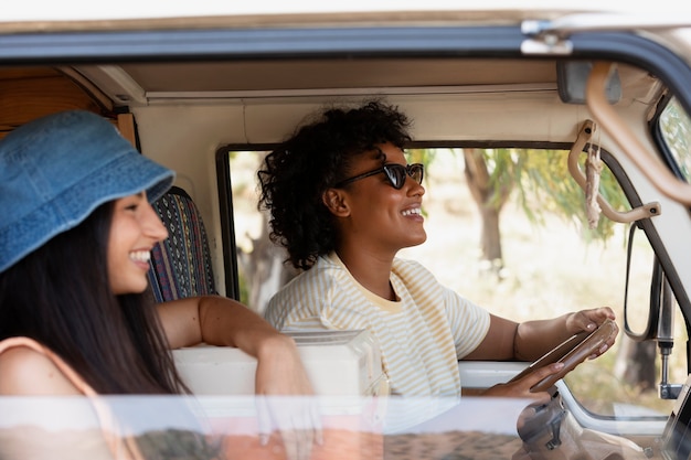 Foto grátis mulheres sorridentes de tiro médio em campervan