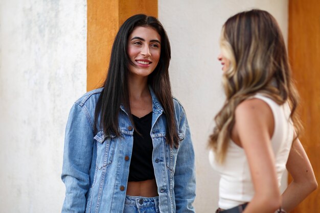 Mulheres sorridentes de tiro médio passando tempo ao ar livre