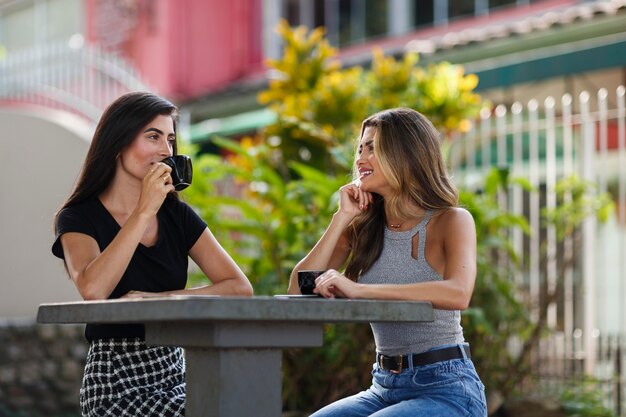 Mulheres sorridentes de tiro médio passando tempo ao ar livre