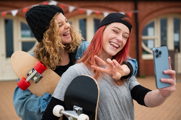 Mulheres sorridentes de tiro médio tomando selfie