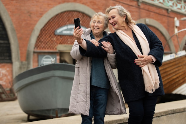 Foto grátis mulheres sorridentes de tiro médio tomando selfie