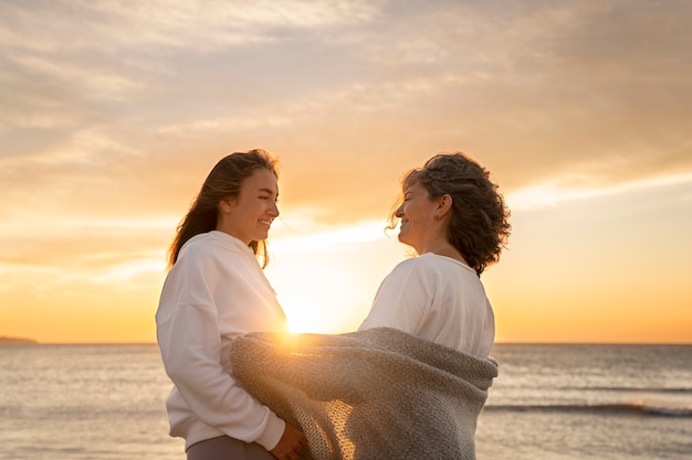 Foto grátis mulheres sorridentes de vista lateral na praia