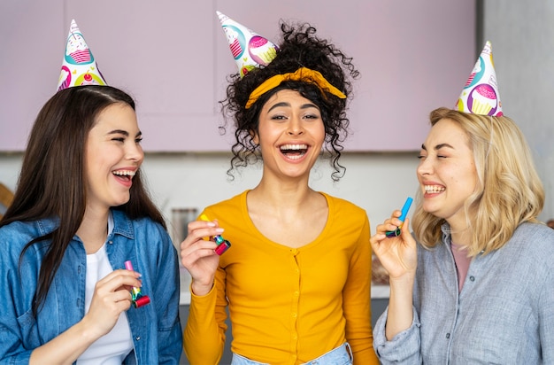 Mulheres sorridentes e felizes com chapéus de festa