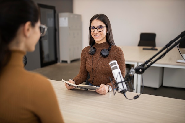 Mulheres sorridentes fazendo um programa de rádio