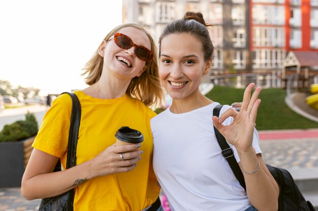 Mulheres sorridentes na cidade usando linguagem de sinais