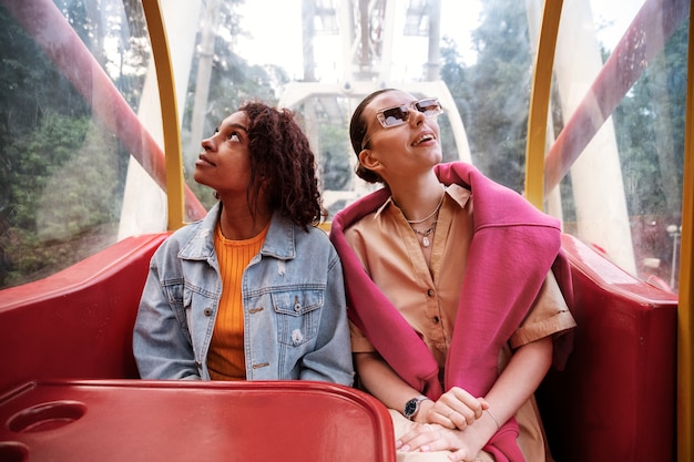 Mulheres sorridentes no tiro médio da roda gigante