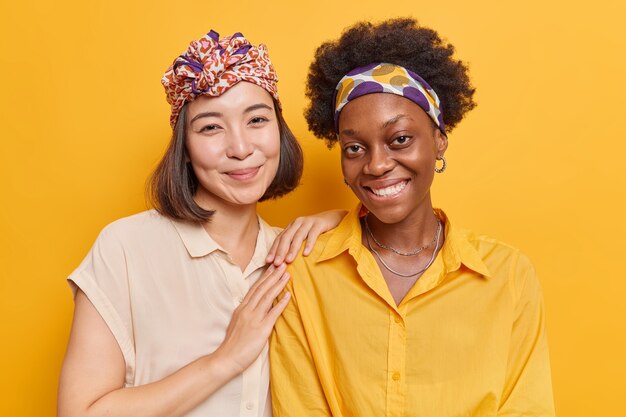 mulheres sorriem agradavelmente passam o tempo livre juntas com saudades uma da outra vestidas casualmente isoladas em amarelo