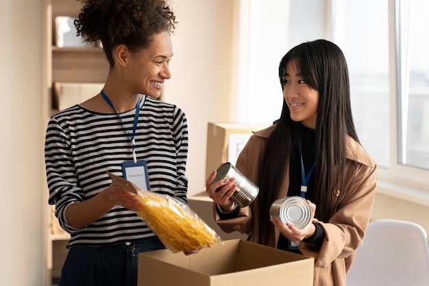 Mulheres tiro médio com doações de alimentos