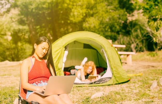 Mulheres, usando, gadgets, enquanto, acampamento