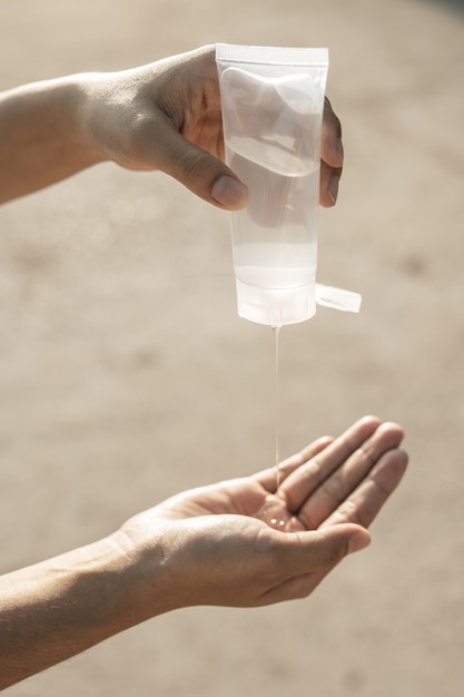 Mulheres vestindo camisas brancas que pressionam o gel para lavar as mãos e limpar as mãos.