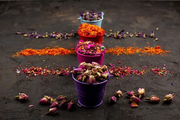 Foto grátis multicolorido folhas flor e outras partículas coloridas em vasos em uma mesa cinza