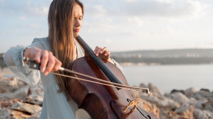 Foto grátis música tocando violoncelo ao pôr do sol com espaço de cópia
