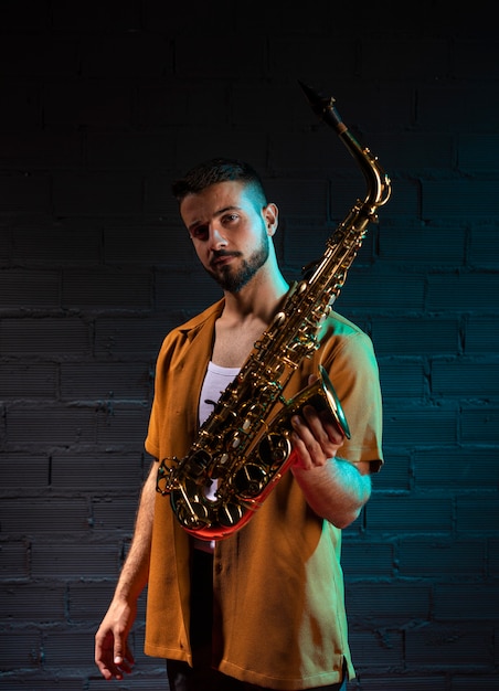 Foto grátis músico bonito segurando um saxofone