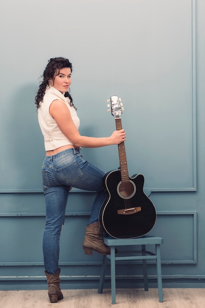 Foto grátis músico com guitarra na cadeira