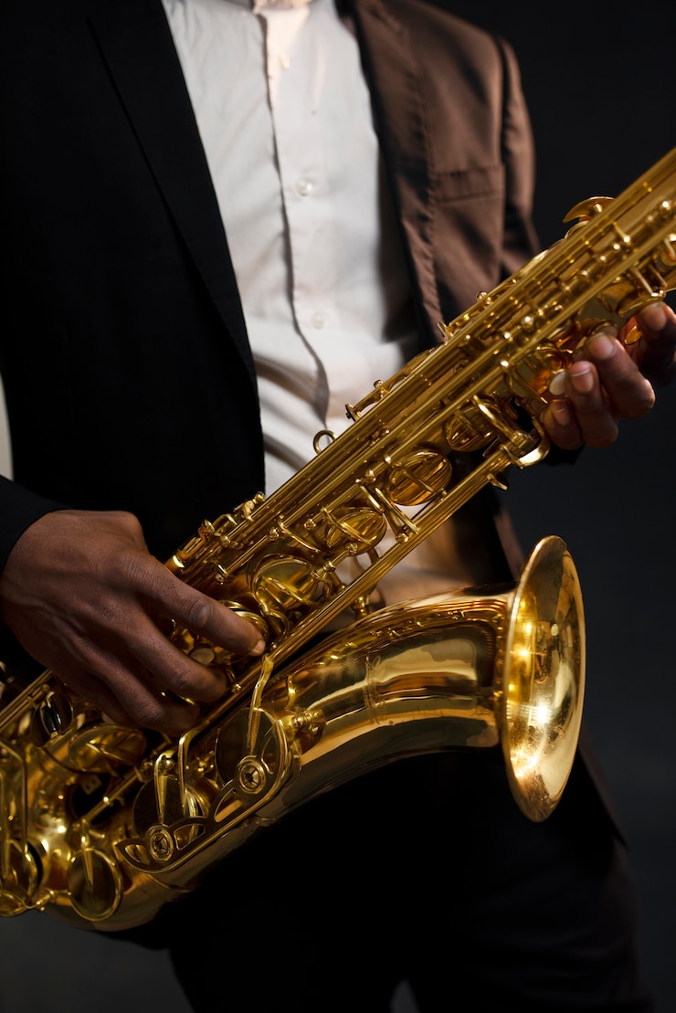 Foto grátis músico de terno segurando o saxofone de perto