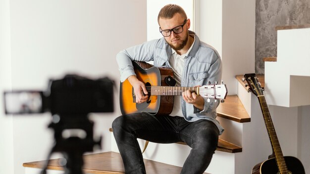 Músico de tiro médio gravando a si mesmo