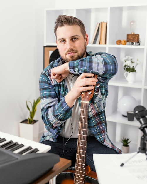 Músico de tiro médio posando com violão