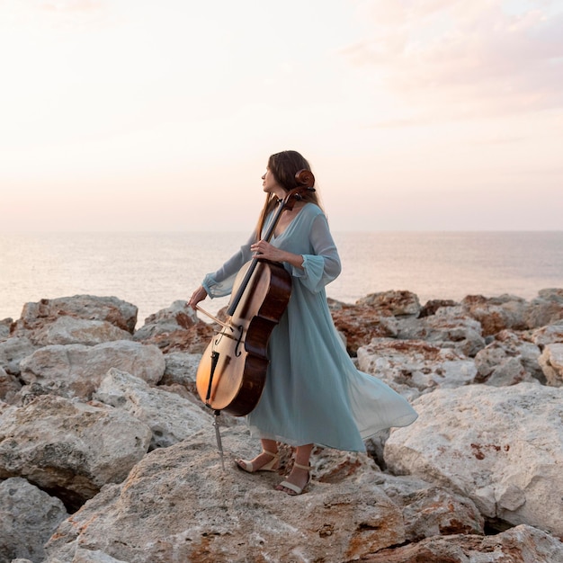 Músico feminino com violoncelo ao ar livre