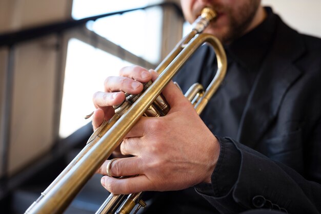 Músico tocando trompete dentro de casa