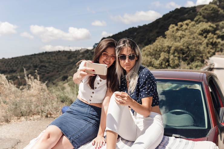 Foto grátis na moda femininos amigos sentado no carro tomando selfie
