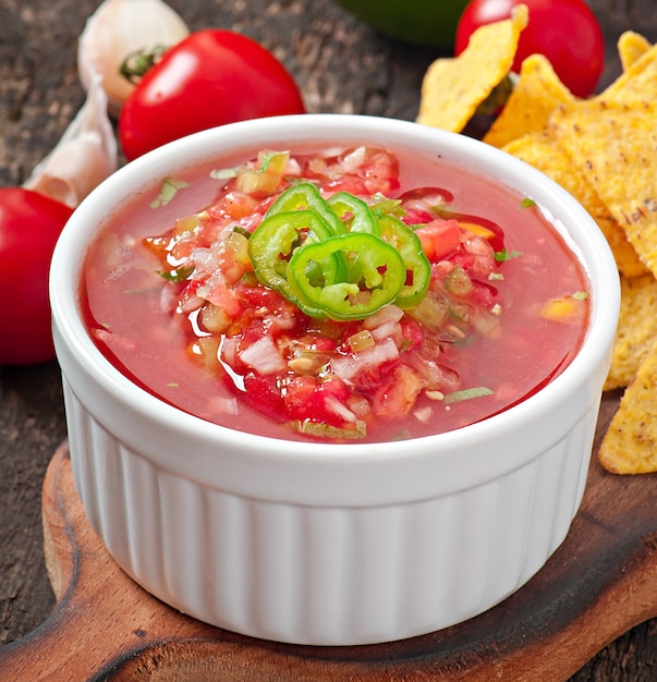 Nacho mexicano chips e molho de salsa em tigela de madeira