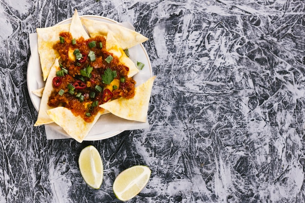 Nachos e fatias de limão na superfície de mármore