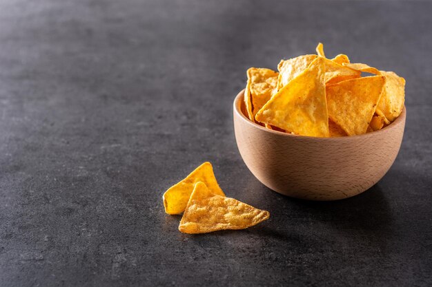 Nachos em tigela de madeira em fundo de ardósia preta