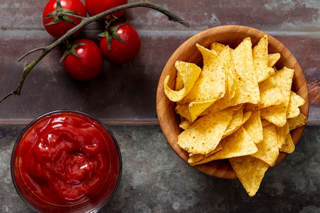 Nachos na tigela e molho de tomate na mesa