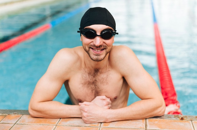 Foto grátis nadador sorridente de alto ângulo na borda da bacia