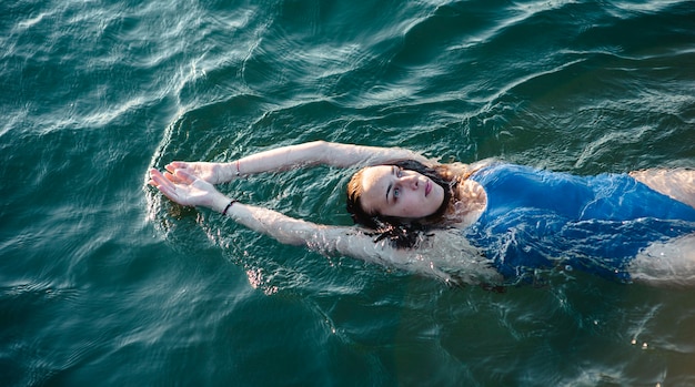 Foto grátis nadadora em ângulo elevado flutuando na água