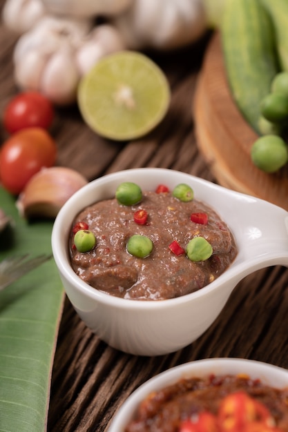 Foto grátis nam phrik kapi com pimenta e limão no piso de madeira.