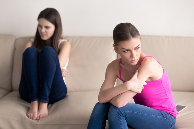 Namoradas sentado no sofá, odiando o outro depois de aquecida argument