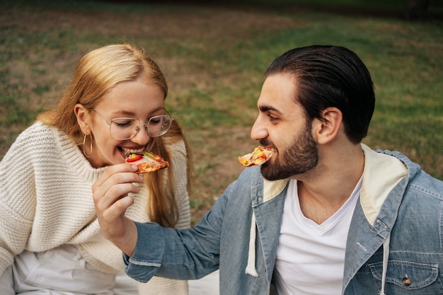 Namorado e namorada comendo pizza