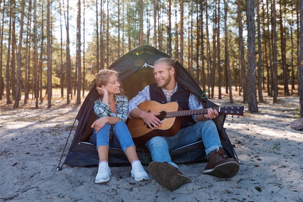 Foto grátis namorado tocando violão na natureza