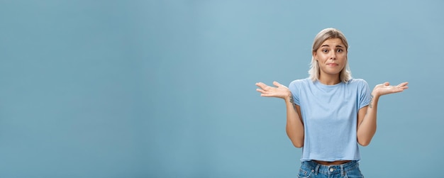 Foto grátis não faço ideia de como ajudar triste retrato de namorada insegura sombrio sentimento de arrependimento encolhendo os ombros com as mãos perto