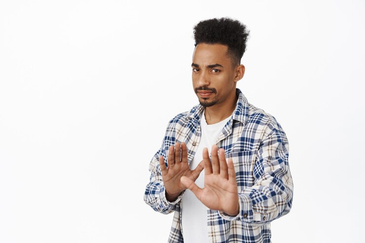 Foto grátis não, obrigado, ele passou. o cara afro-americano sério relutante estende as mãos em um gesto de parada, rejeitando a oferta, recusa e recusa, pede para ficar longe, não se aproxime no branco.