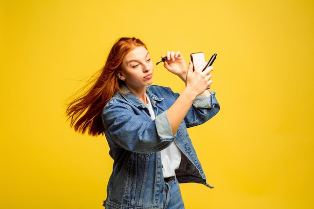 Não precisa de selfie para maquiagem. Retrato de mulher caucasiana no espaço amarelo