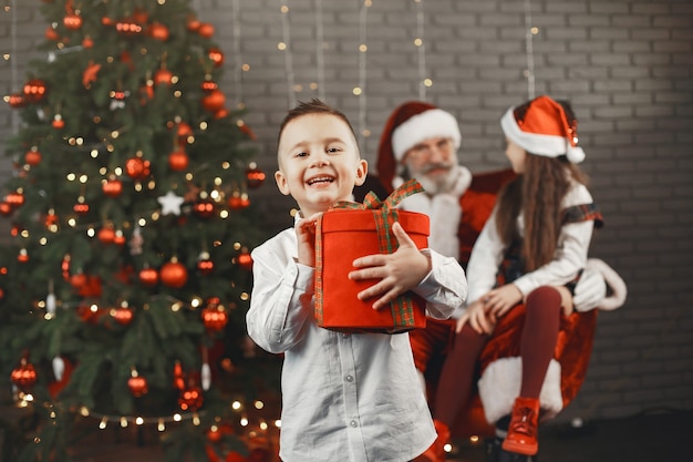 Natal, crianças e presentes. papai noel trouxe presentes para as crianças. crianças alegres com presentes abraçando o papai noel.