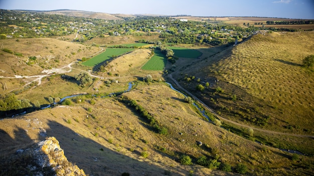 Natureza da Moldávia, vale com rio, encostas com vegetação esparsa